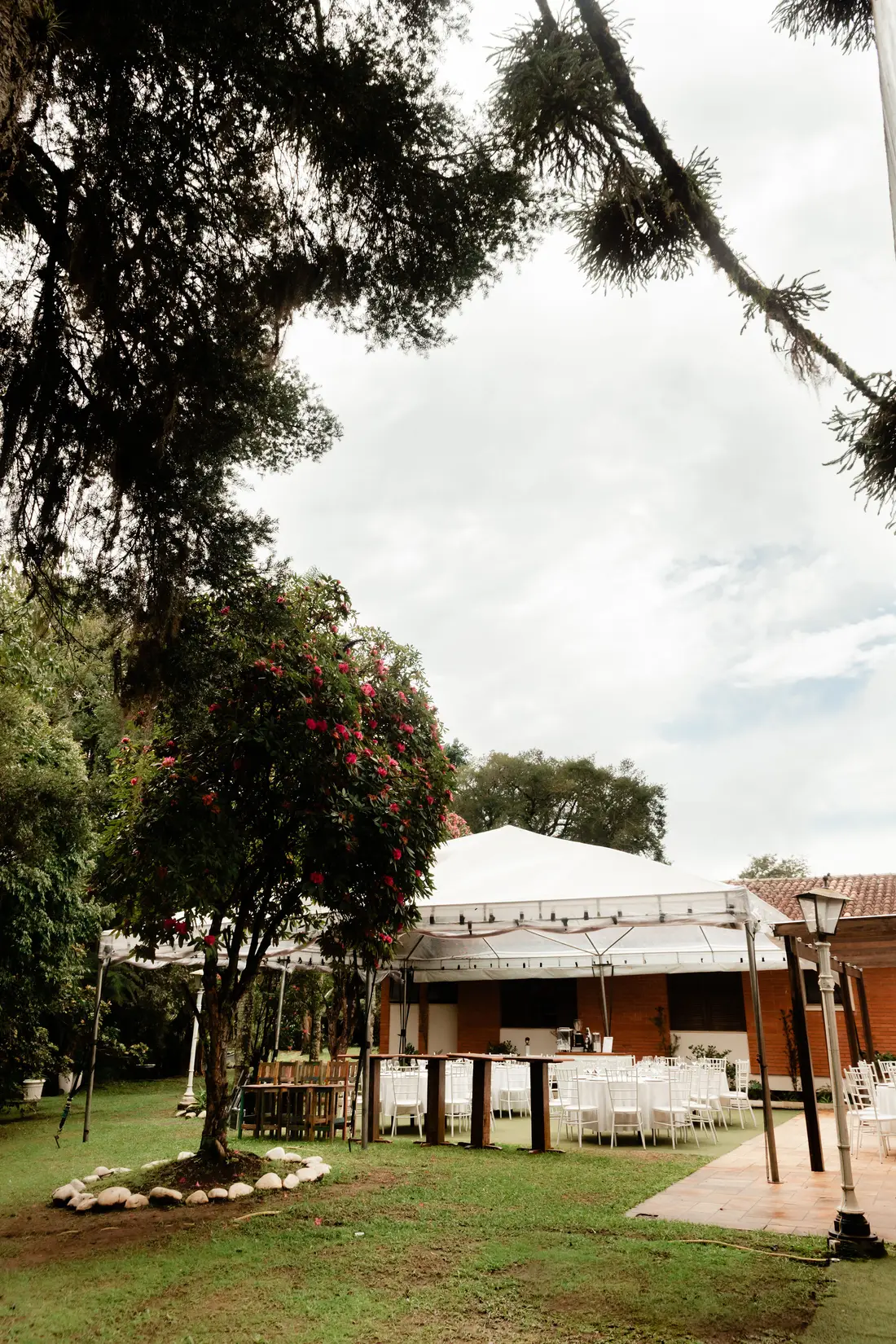 Jardim da Mansão Yarden com tenda de recepção entre as árvores
